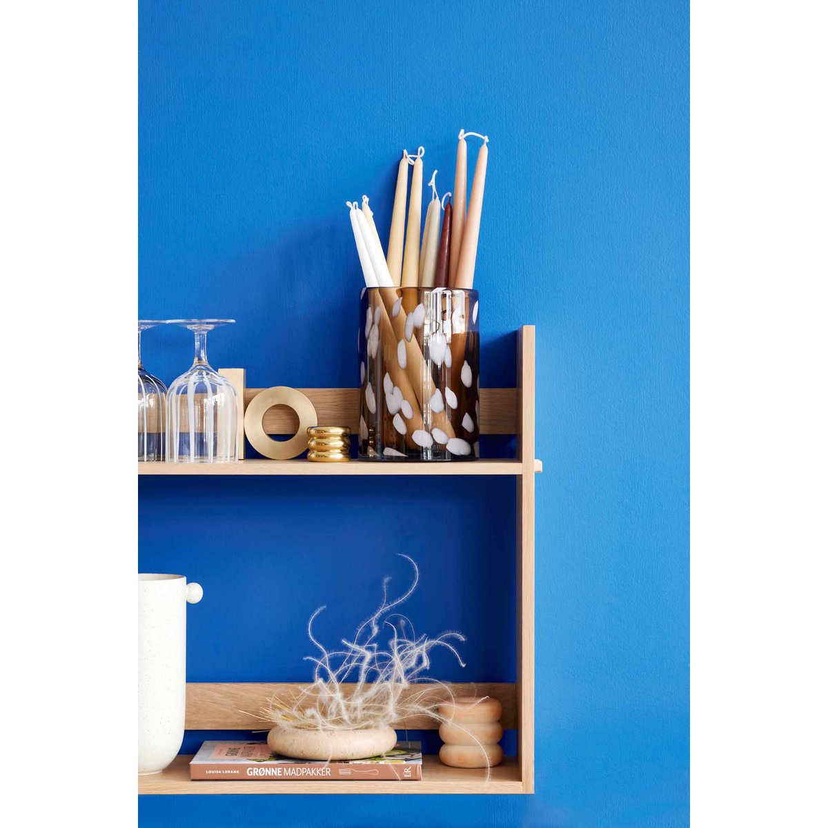 Wooden shelf with decorative items against a blue wall