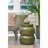 Green ceramic stool with decorative vase in a bathroom setting