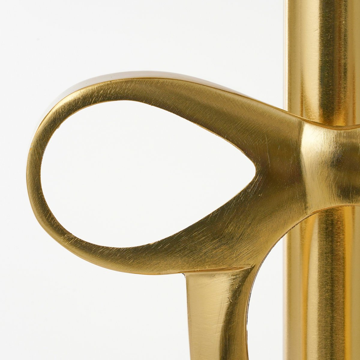 Close-up of a gold-colored object with a handle on a white background